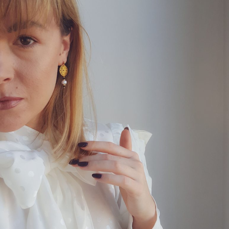 eleganckie kolczyki z perłami i czarnym kamieniem na modelce z daleka